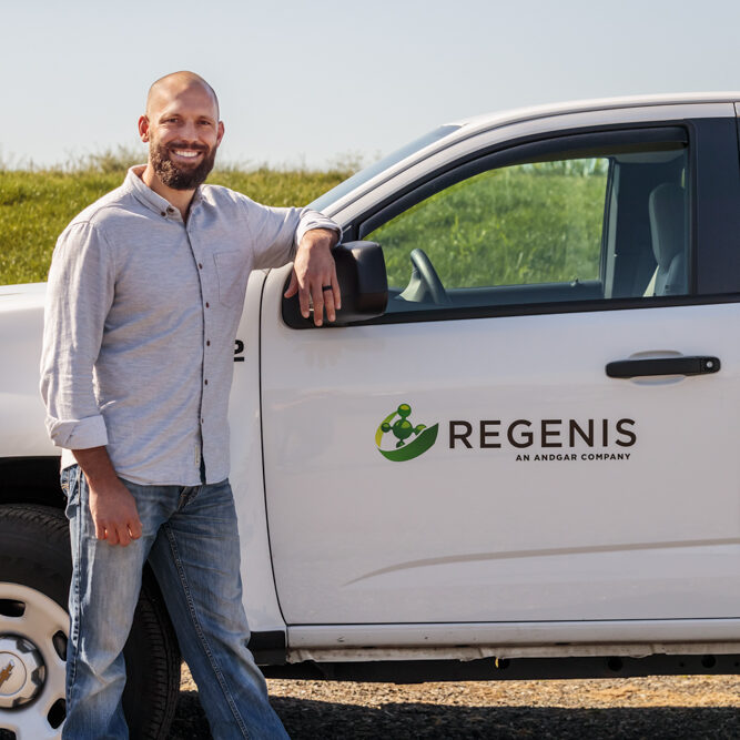 Regenis team member in front of a company truck